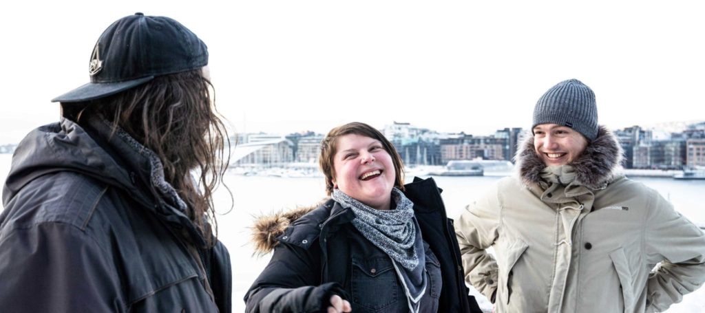 Unge mennesker med vinterklær smiler og ler.