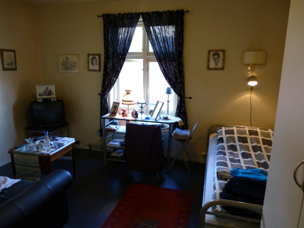 Et rom med seng, sofa og bord på Blå Kors Bosenter Ålesund