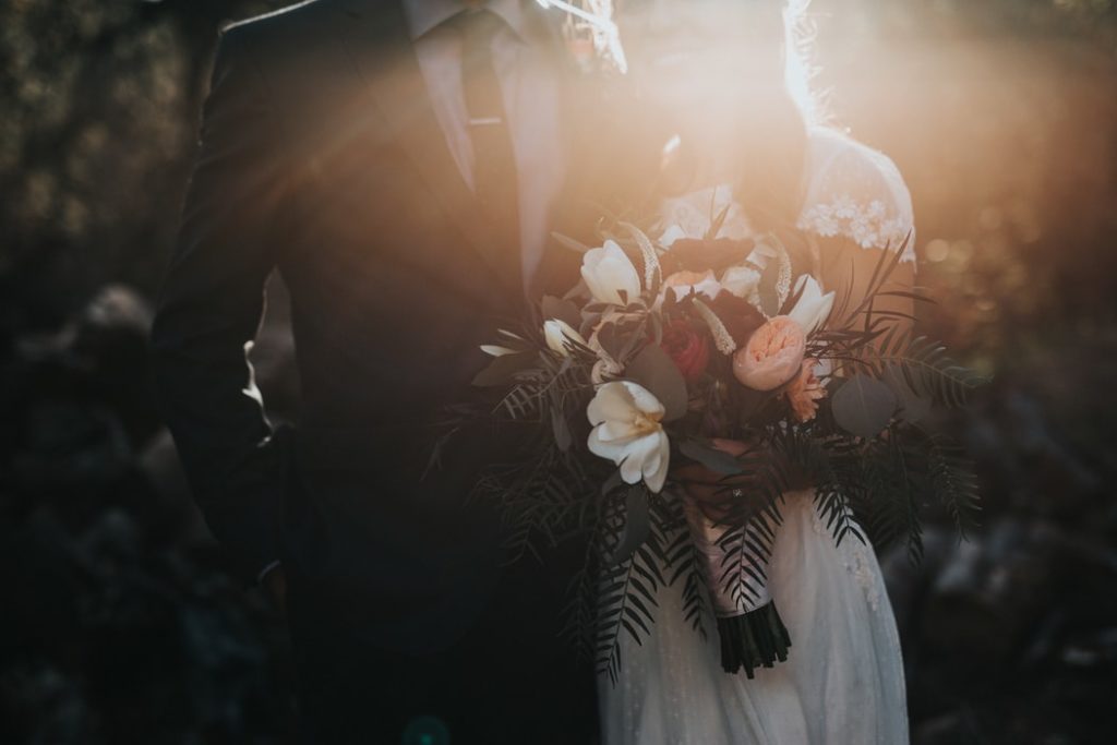 Brudepar med en vakker blomsterbukett