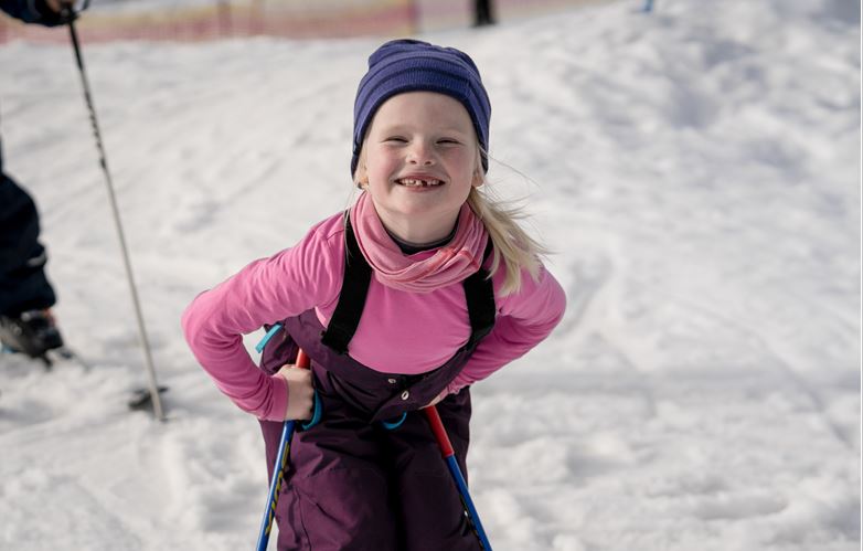 Jente med ski som har vært med på Blå Kors sin ferie på Hovden. Hun smiler bredt.