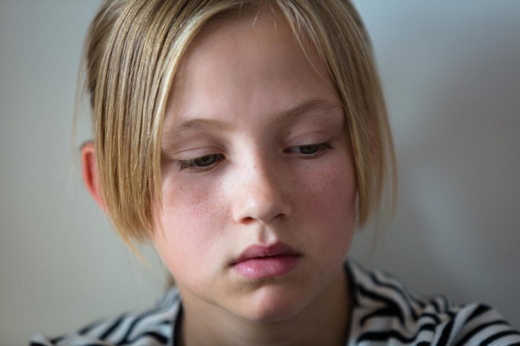 Jente sitter alene og er lei seg
