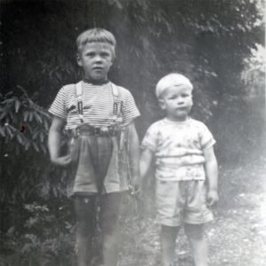 Et svart hvitt bilde fra gamle dager av Terje Forsberg og broren hans. De står ved et tre og holder hender