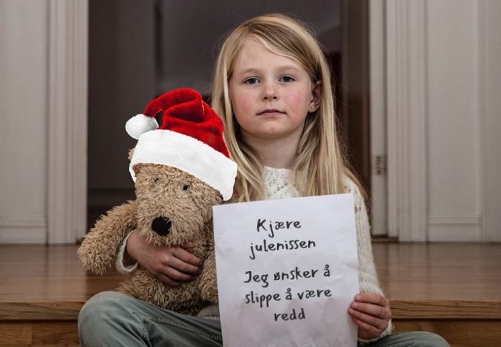 Jente i en trapp med bamse og lapp