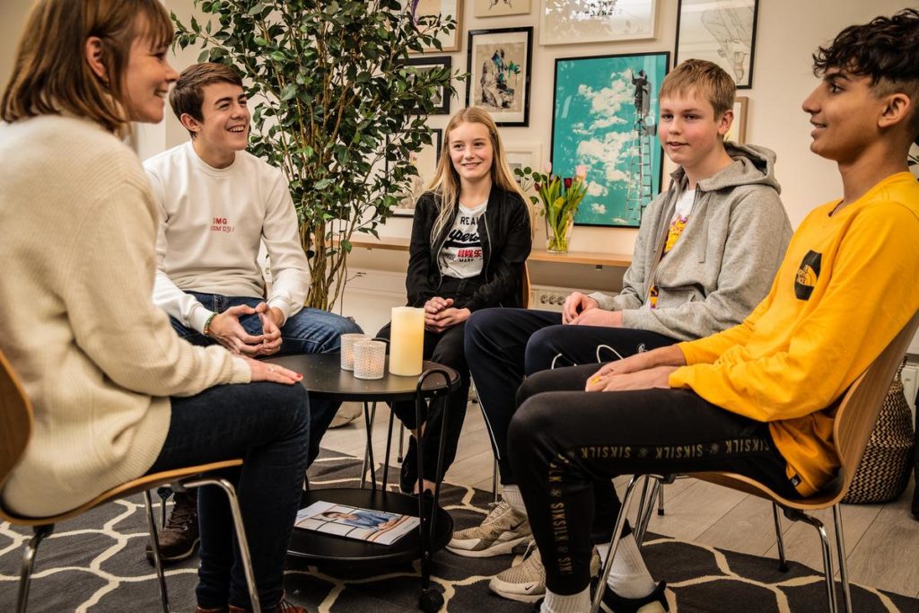 Ungdommer som sitter i gruppe og får veiledning