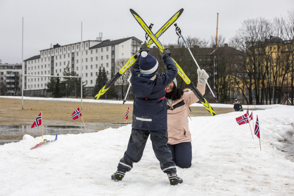 Gutt og mamma løfter skiene i være