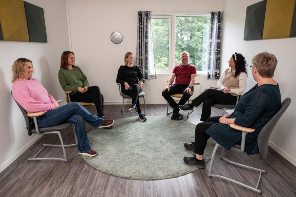 Personer som sitter på stoler i en ring