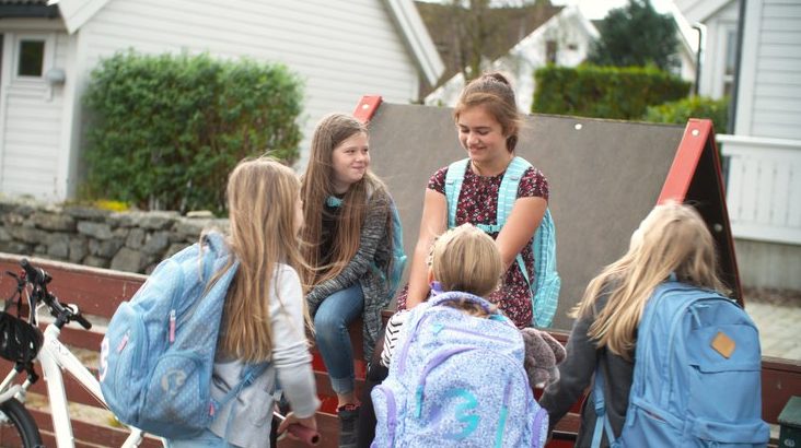 Jenter i ring. En gjeng med skolejenter med ryggsekker.