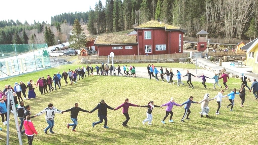 Ungdom danser i ring på stor gressplen ved Aglo videregående skole