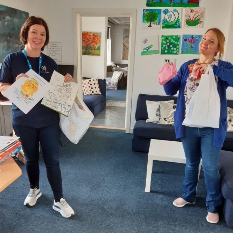To damer fra Barnas Stasjon i Drammen viser frem aktivitetshefter og annet som skal pakkes i påskeposer til sårbare familier