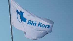 Blå Kors flagg som flagrer i vinden