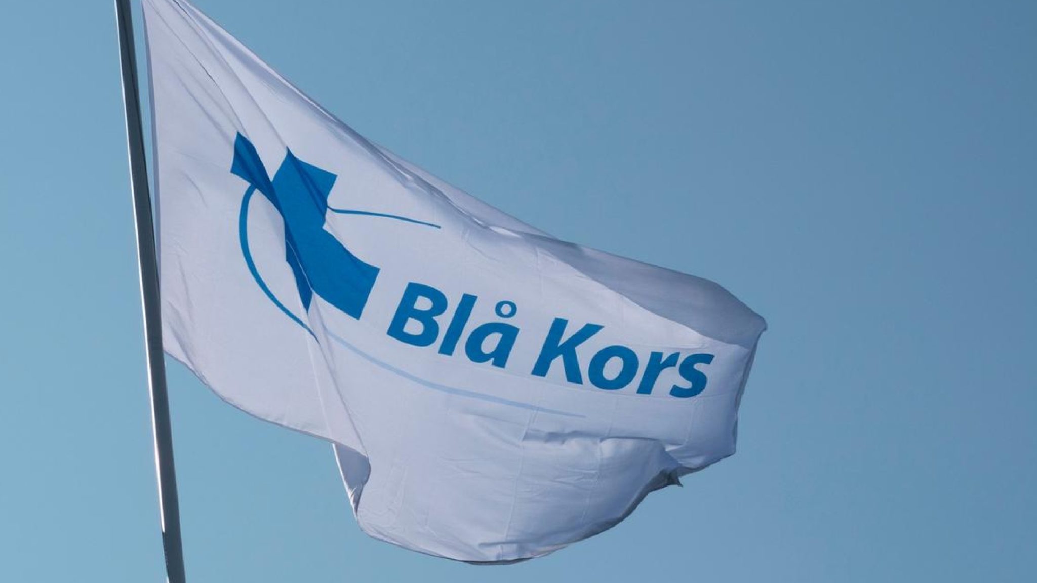 Blå Kors flagg som flagrer i vinden