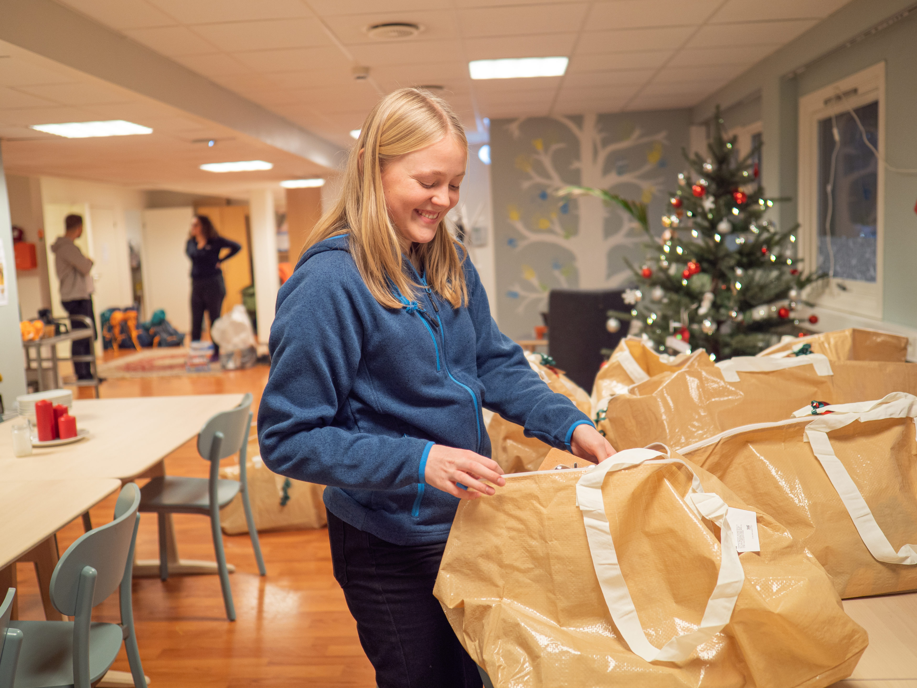 Ansatt ved Blå Kors barnas stasjon pakker julegaver