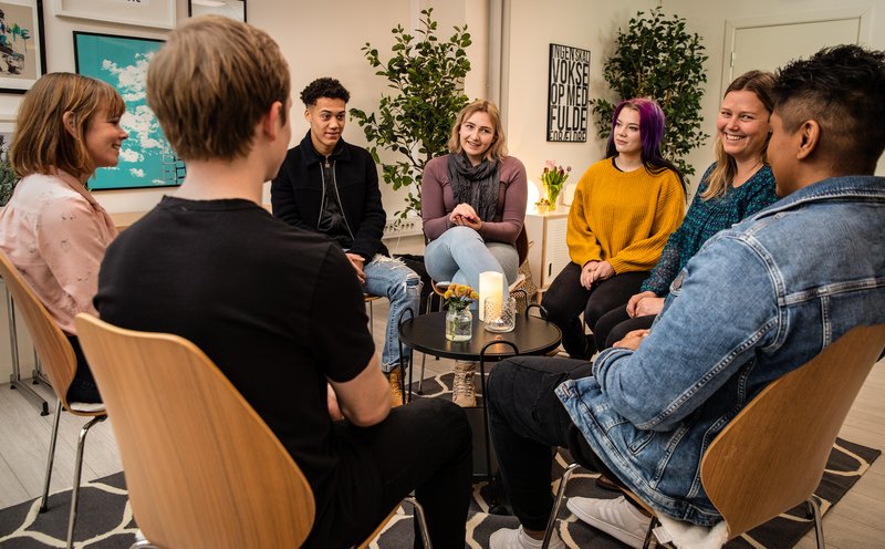 Gjeng med ungdommer i terapi. Samtale rundt et bord