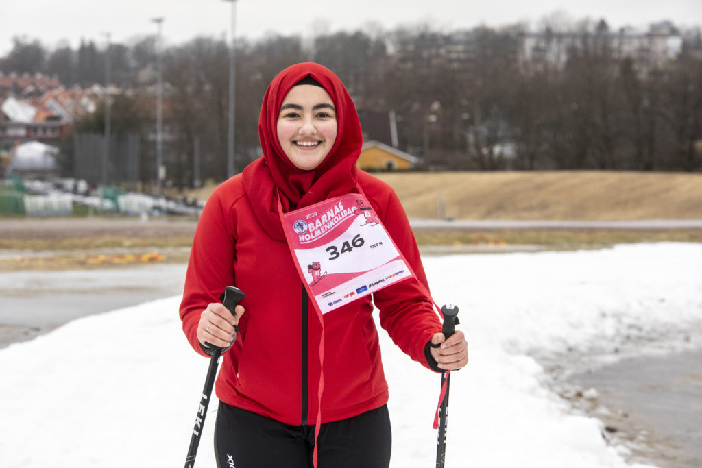 Jente med rød genser på ski