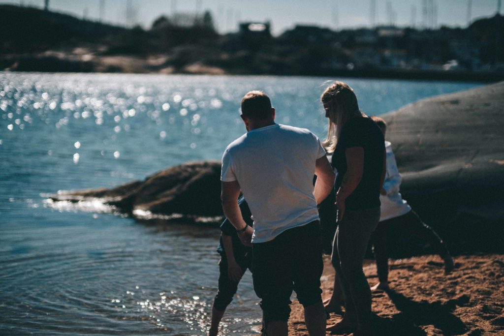 Familie som leker ved stranda en sommer