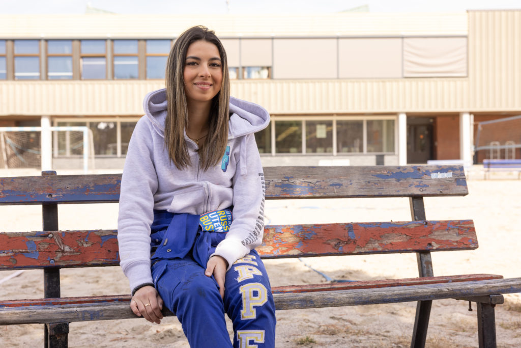 Russepresident Anabella Reppe sitter på en benk i skolegården. Hun går i 3. klasse på Porsgrunn videregående og er skolens russepresident. På seg har hun på seg sin blå russedress.