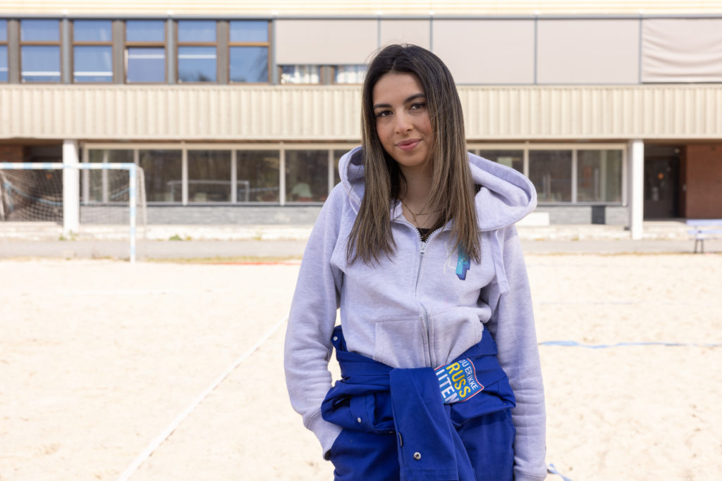 Russepresident Anabella Reppe sitter på en benk i skolegården. Hun går i 3. klasse på Porsgrunn videregående og er skolens russepresident. På seg har hun på seg sin blå russedress.