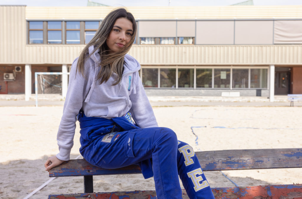 Russepresident Anabella Reppe sitter på en benk i skolegården. Hun går i 3. klasse på Porsgrunn videregående og er skolens russepresident. På seg har hun på seg sin blå russedress.