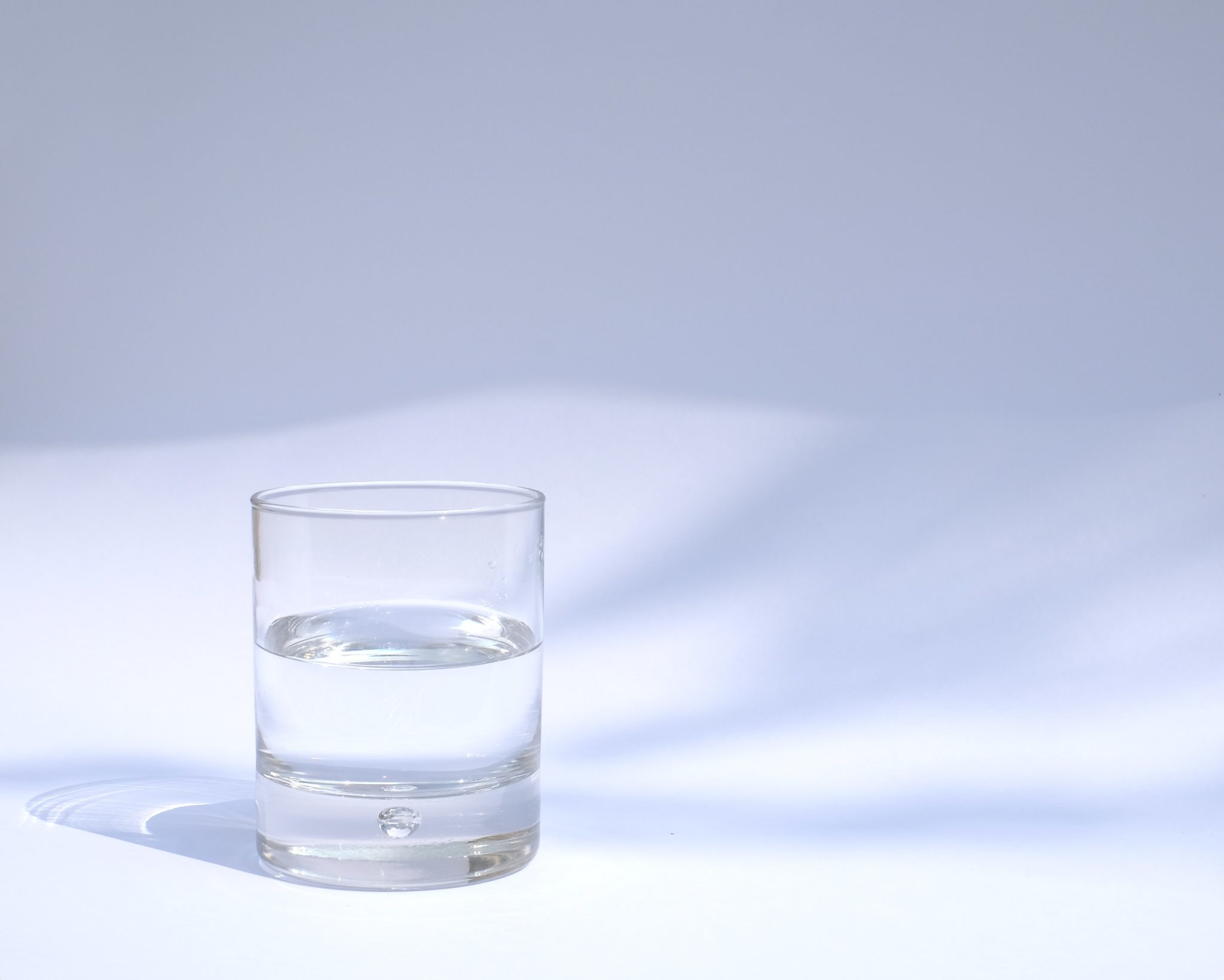 Glass med vann med hvit bakgrunn