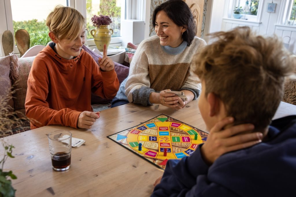 Barn spiller brettspill med voksen uten alkohol. Dette er en hyggelig aktivitet barn kan oppleve uten alkohol tilstede.