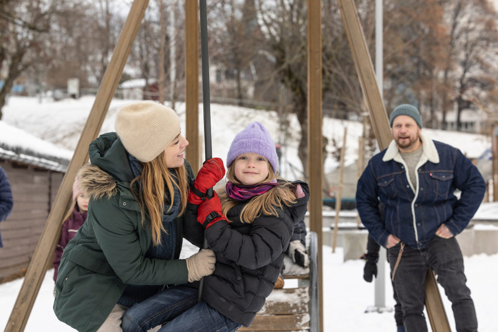 Barnefamilie leker på lekeplass og illustrerer hva Valentine's Day kortet kan bidra til 