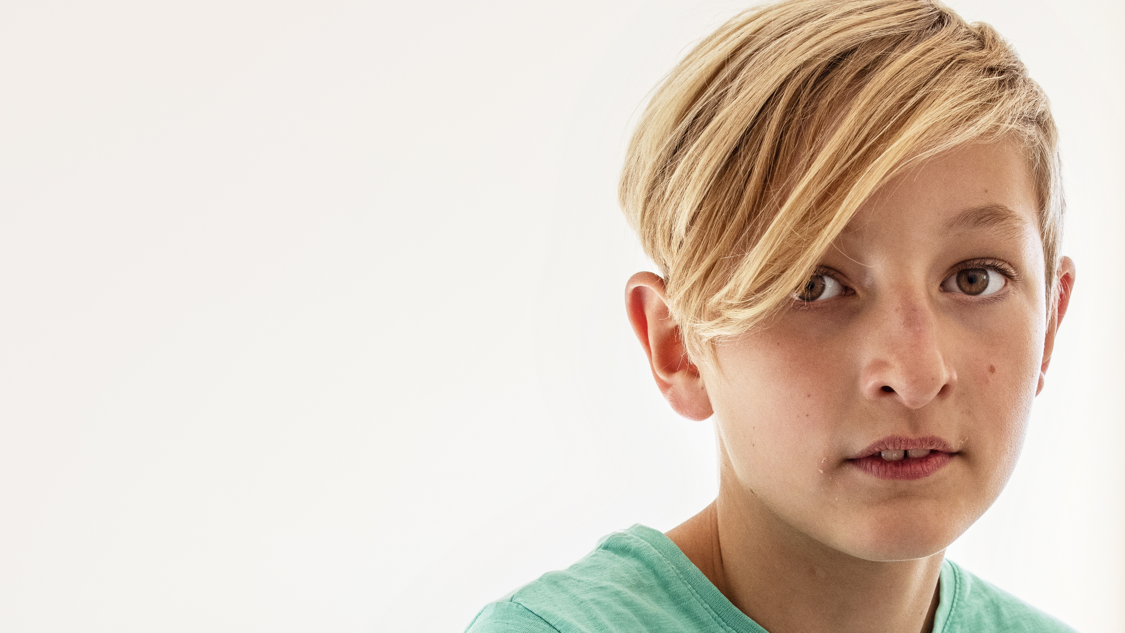 Gutt med brune øyne og blondt hår ser inn i kameraet.