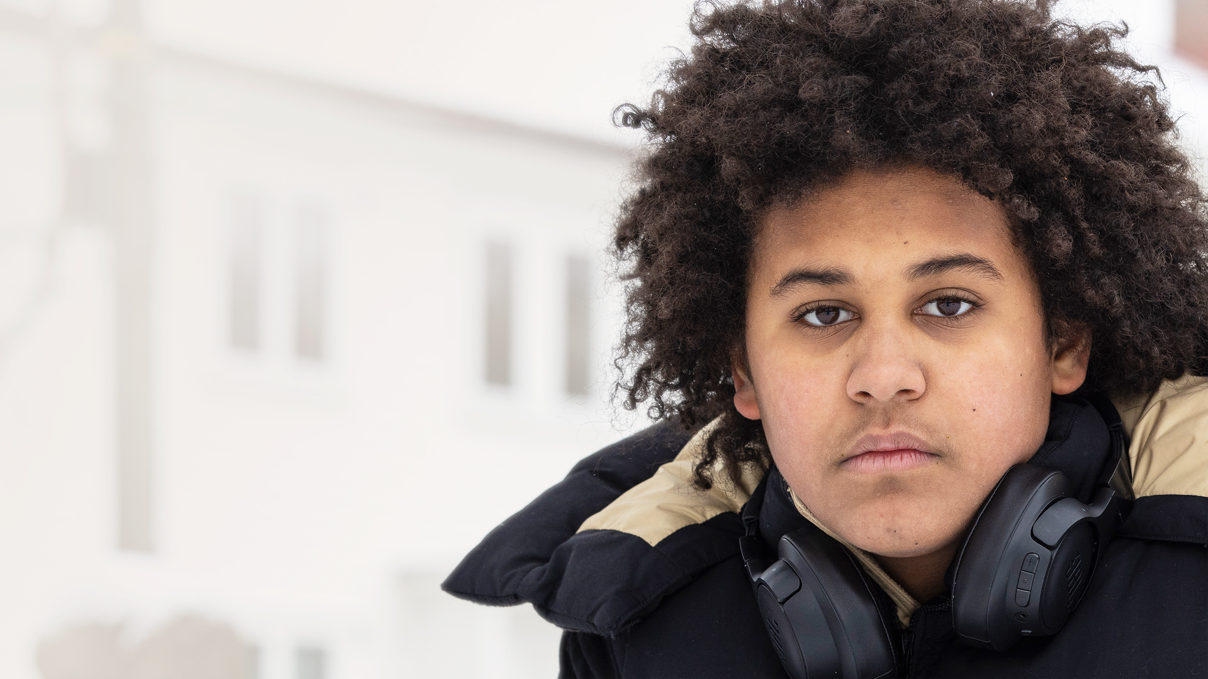 Gutt med brune øyne og brunt hår ser inn i kameraet.