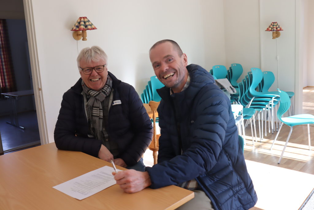 Arvid Solheim og Olav Ausel signerer de siste papirene.