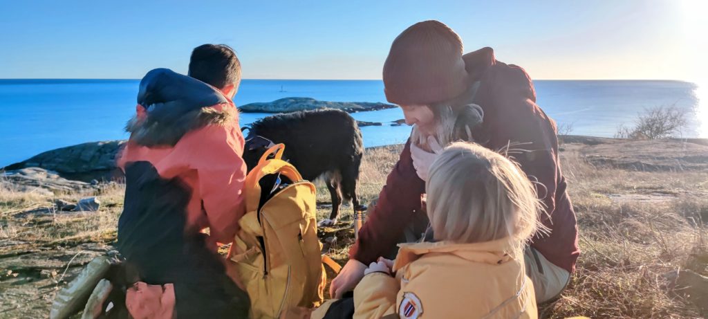 to voksne og et barn er på tur ved havet