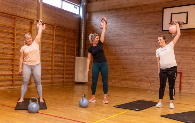 tre kvinner trener kettlebells