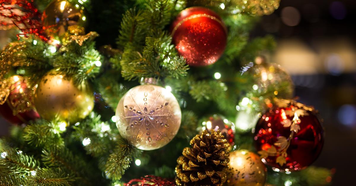 Mange ulike julekuler som henger på et juletre. Det er også lys på treet