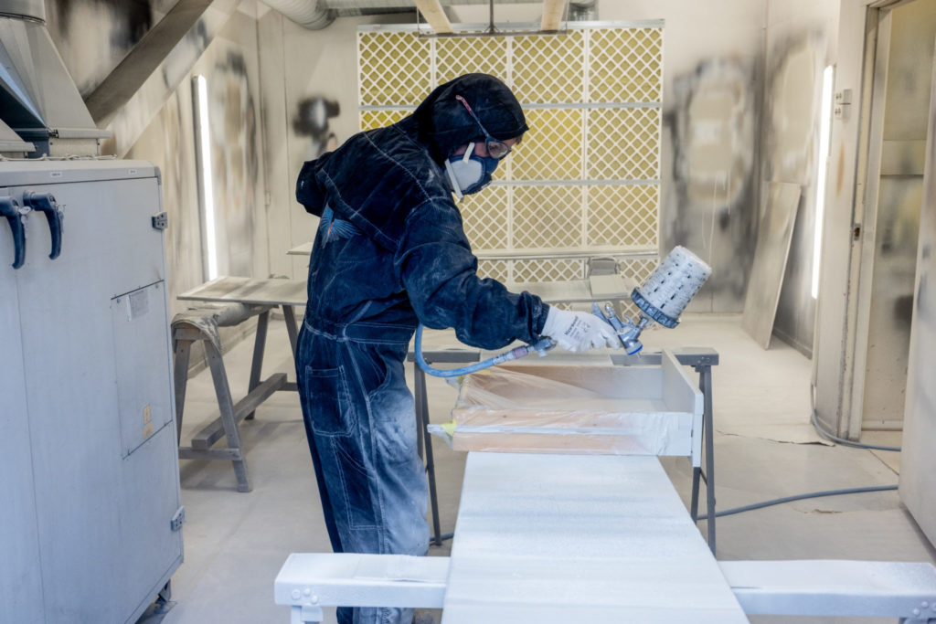 en mann sprøytemaler en skuff med maske og drakt på